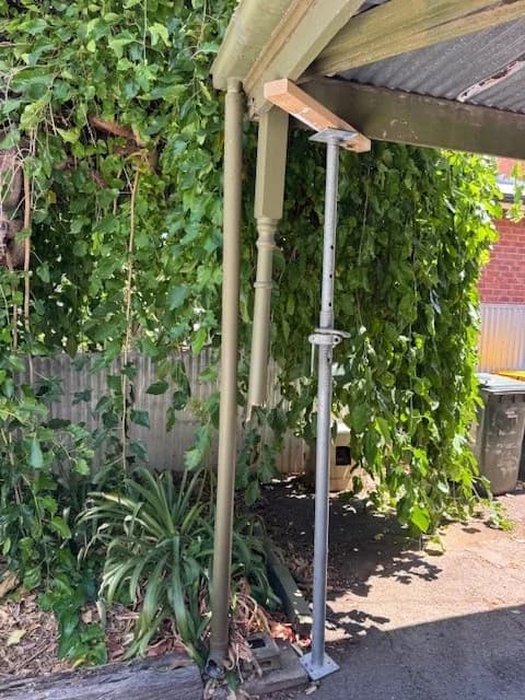 Adjustable temporary prop supporting the edge of a roofed outdoor structure