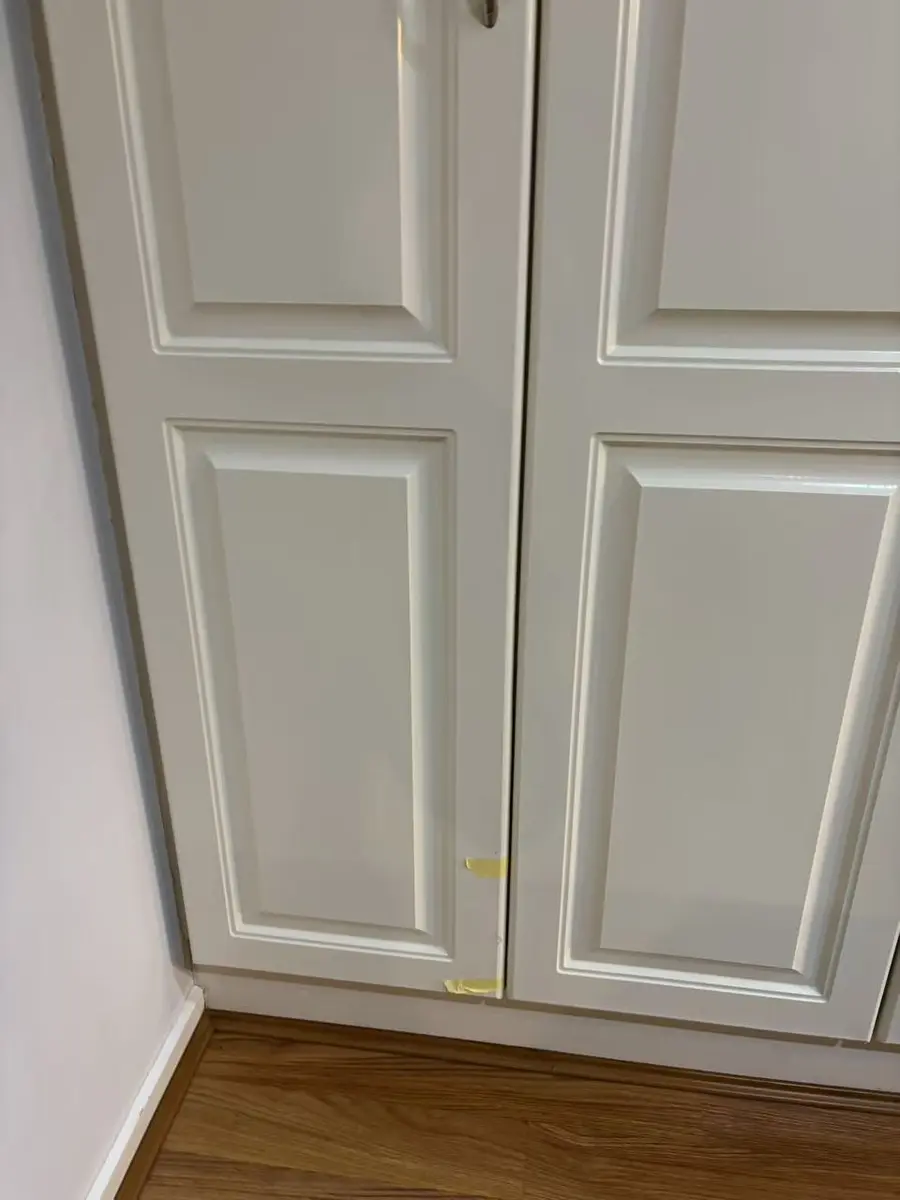 Tall white kitchen cupboard doors aligned after hinge adjustment
