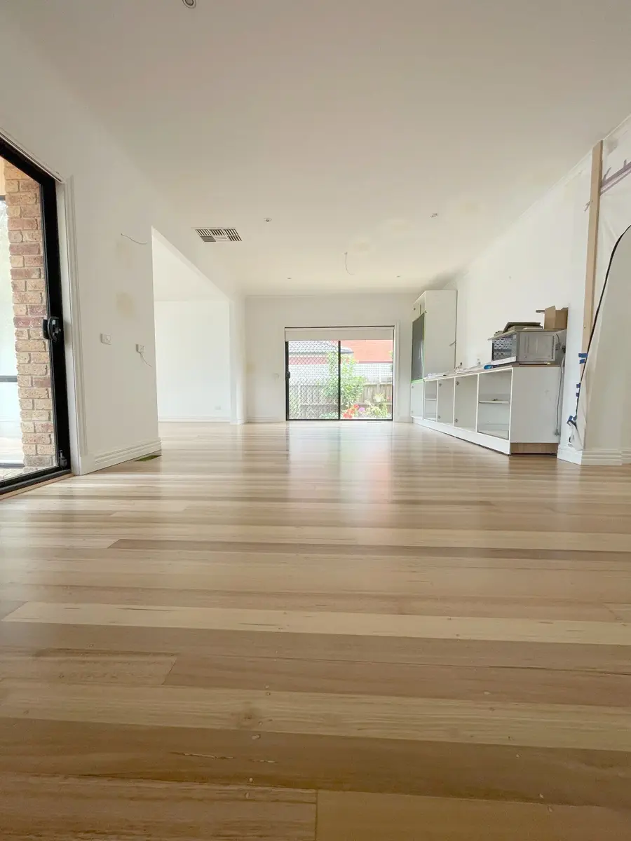 Light-toned timber flooring extending through an open-plan living and kitchen area