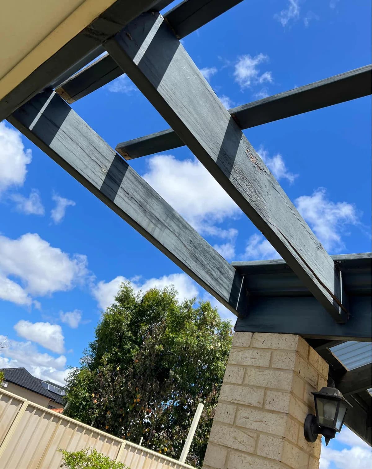 Weathered outdoor pergola beams before timber and roof repairs